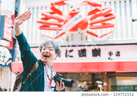 A middle-aged male photographer taking pictures of the city of Osaka 124751552
