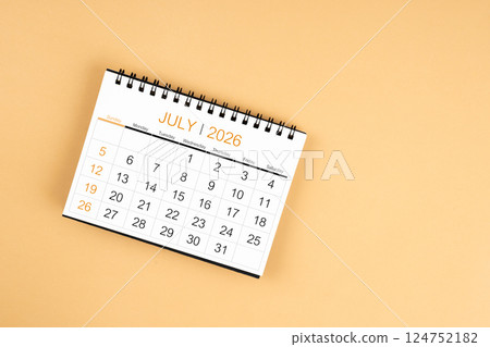 Top view of July 2026 desk calendar on yellow pastel background. Top view of July 2026 desk calendar on yellow pastel background. 124752182