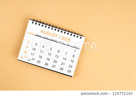 Top view of August 2026 desk calendar on yellow pastel background. 124752183