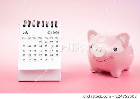 Desk calendar for July 2026 and pink piggy bank on pink background. 124752508