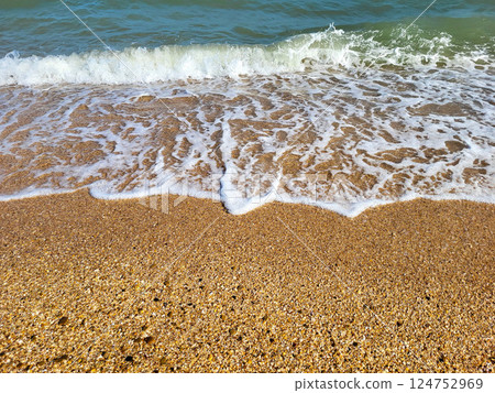 The concept of recreation. Beautiful azure sea with white foam and a beach on a clear sunny day 124752969