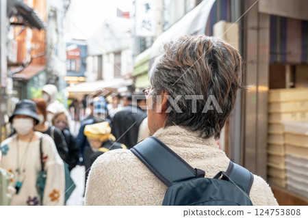 Rear view of a man walking down the street 124753808