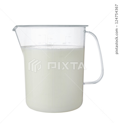Milk in a plastic measuring cup isolated. 124754367