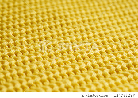Close-up of yellow fabric with a knitting pattern. Textiles. Banner for advertising goods for creativity. Close-up of yellow fabric with a knitting pattern. Textiles. Banner for advertising goods for creativity. 124755287