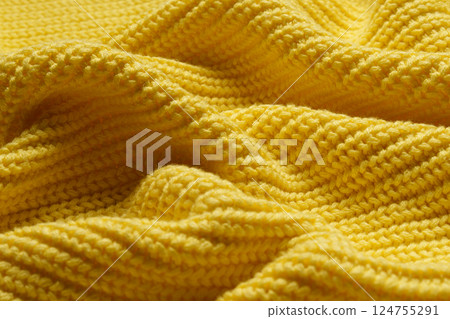 Knitted clothes. Waves of yellow fabric with a knitting pattern. Textiles. Banner for advertising goods for creativity. 124755291