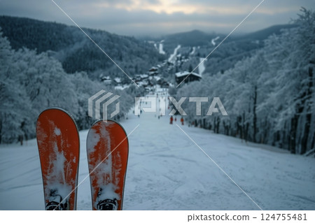 Snowy Winter Evening at a Ski Resort With Skis and Cozy Lodge Illuminated by Warm Lights 124755481