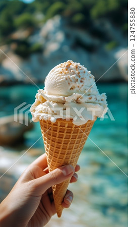 Creamy Ice Cream Cone on a Rocky Edge Overlooking a Serene Beach and Blue Ocean 124755880