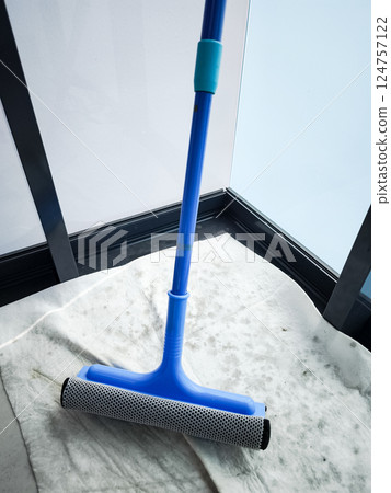 Cleaning windows with a blue squeegee during spring cleaning 124757122