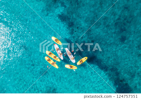 Aerial view of yellow kayaks in blue sea at sunset in summer 124757351