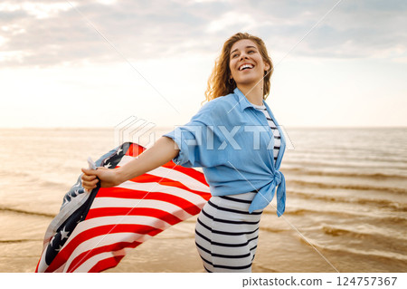 Young woman with American flag on beach. Patriotic holiday. Independence Day concept Young woman with American flag on beach. Patriotic holiday. Independence Day concept 124757367