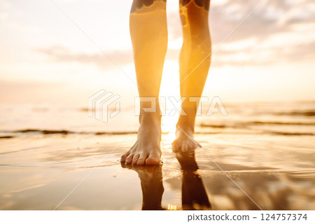 Woman leg close up walking on sand relaxing in beach at sunset. Sexy lean and tanned legs. Woman leg close up walking on sand relaxing in beach at sunset. Sexy lean and tanned legs. 124757374