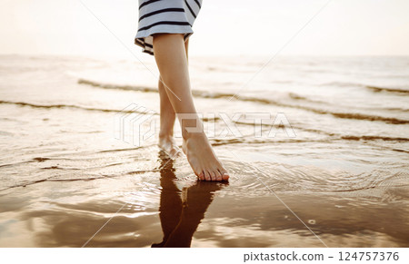 Woman leg close up walking on sand relaxing in beach at sunset. Sexy lean and tanned legs. Woman leg close up walking on sand relaxing in beach at sunset. Sexy lean and tanned legs. 124757376