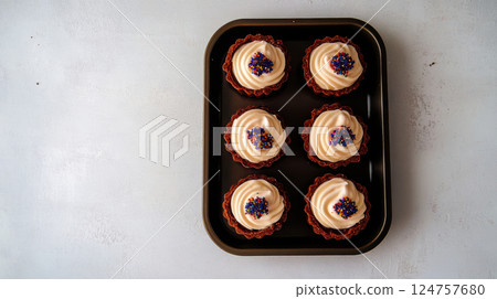 Chocolate mini tartlets with crisp cocoa crust, smooth cream filling, and colorful sprinkles, captured in soft, diffused lighting on a white background. 124757680