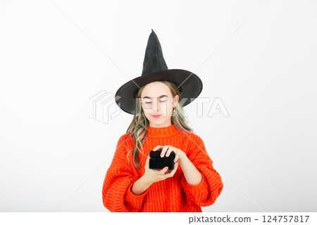 Portrait smiling girl in witch black hat, with pumpkin jack sweet candy. Isolated white background Portrait smiling girl in witch black hat, with pumpkin jack sweet candy. Isolated white background 124757817