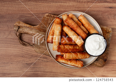 fried spring rolls with cheese, on a wooden background, with cream sauce, no people, fried spring rolls with cheese, on a wooden background, with cream sauce, no people, 124758543