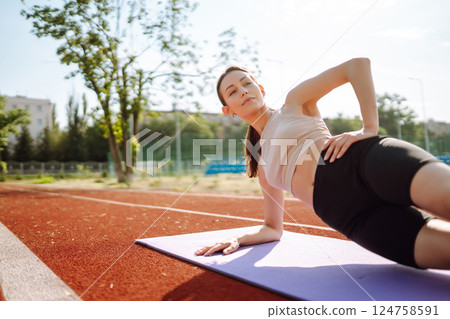 Young woman in sports outfit doing exercises outdoors in morning. Sport, Active life sports training Young woman in sports outfit doing exercises outdoors in morning. Sport, Active life sports training 124758591