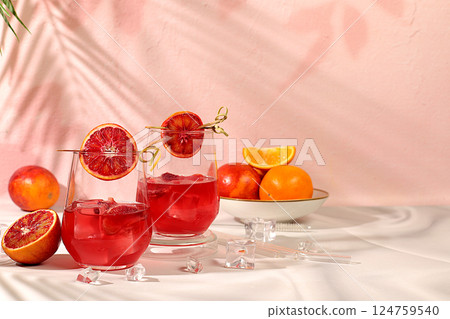 Banner with glasses of alcoholic drinks and tropical fruits. Royal cocktail of blood orange, ice cubes, rum and tequila. Concept of summer party and rest in a restaurant. Menu for a bar or cafe Banner with glasses of alcoholic drinks and tropical fruits. Royal cocktail of blood orange, ice cubes, rum and tequila. Concept of summer party and rest in a restaurant. Menu for a bar or cafe 124759540