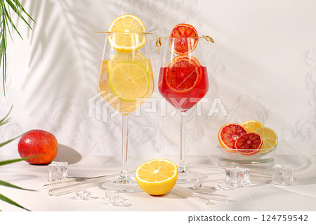 Flyer with glasses of alcoholic drinks and tropical fruits. Two royal cocktails of blood orange and lemon, ice cubes, rum and tequila. Concept of a summer party and rest in a restaurant. 124759542