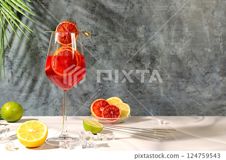 Banner with glasses of alcoholic drinks and tropical fruits. Royal cocktail of blood orange, ice cubes, rum and tequila. Concept of summer party and rest in a restaurant. Menu for a bar or cafe Banner with glasses of alcoholic drinks and tropical fruits. Royal cocktail of blood orange, ice cubes, rum and tequila. Concept of summer party and rest in a restaurant. Menu for a bar or cafe 124759543