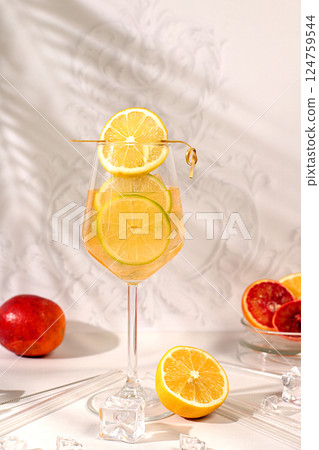 Royal cocktail of orange and lemon, ice cubes, rum and tequila. Flyer with a glass of alcoholic drink and tropical fruits. Concept of a summer party and rest in a restaurant. Menu for a bar or cafe 124759544
