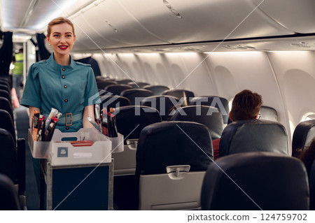 An Airline Flight Attendant is serving passengers in a modern and comfortable cabin space 124759702