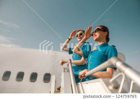 The airline crew is welcoming passengers who have just disembarked from the aircraft steps The airline crew is welcoming passengers who have just disembarked from the aircraft steps 124759765