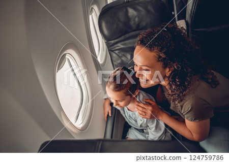 A Mother and Her Child Happily Enjoying a Beautiful Plane View Together from the Window A Mother and Her Child Happily Enjoying a Beautiful Plane View Together from the Window 124759786