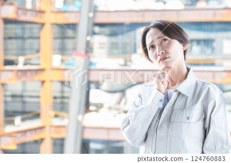 建築工地上一名表情困擾的女工 建築工地上一名表情困擾的女工 124760883