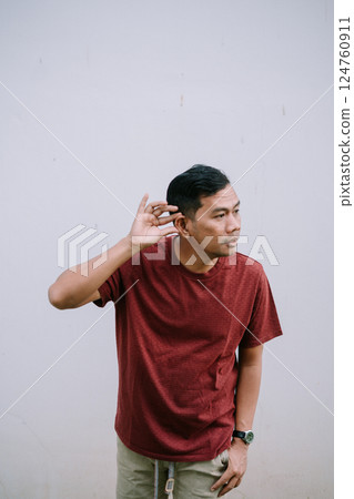 Attentive man trying to listen closely, holding hand to ear hearing 124760911
