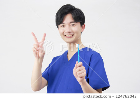 Dentist man holding toothbrush peace sign white background Dentist man holding toothbrush peace sign white background 124762042