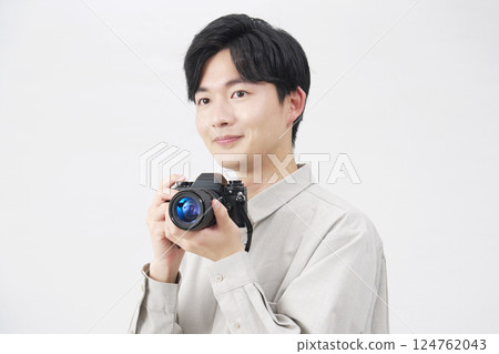 Man holding a film camera on white background 124762043