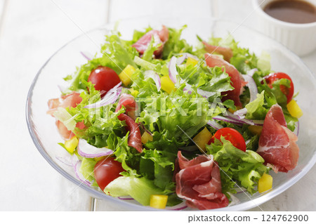 Bright salad of leaf lettuce and prosciutto 124762900