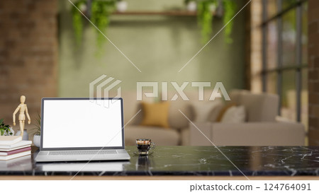 The white screen laptop and coffee on black marble table in a living room or lounge with green wall 124764091