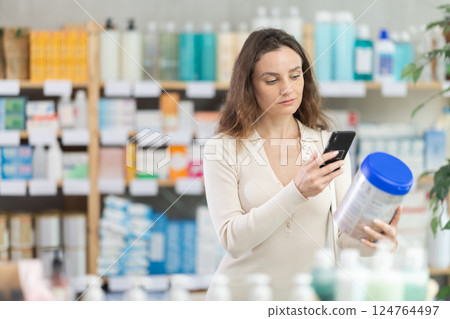 Adult woman scanning qr code of baby formula Adult woman scanning qr code of baby formula 124764497