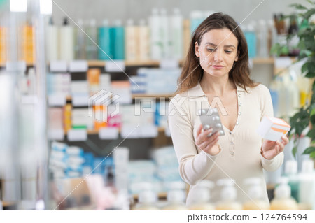 Girl in summer clothes looking for medicine in pharmacy 124764594