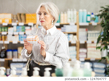 Mature woman in summer clothes buys paracetamol medicine at pharmacy Mature woman in summer clothes buys paracetamol medicine at pharmacy 124764777