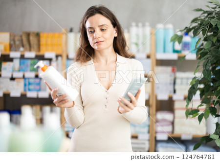 Adult woman chooses cream at pharmacy 124764781