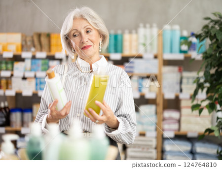 Woman choosing shampoo at the pharmacy Woman choosing shampoo at the pharmacy 124764810