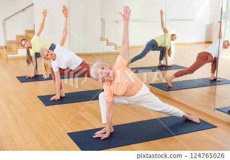 Group of women exercising during yoga class Group of women exercising during yoga class 124765026