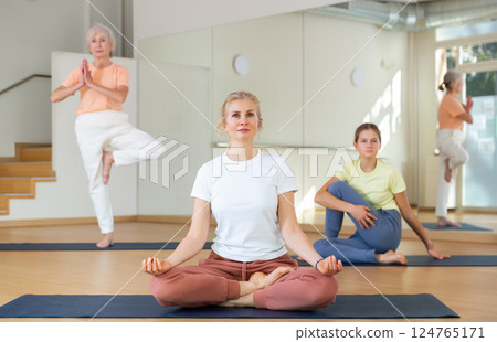 Continuity of generations - family in lotus position doing yoga in gym Continuity of generations - family in lotus position doing yoga in gym 124765171