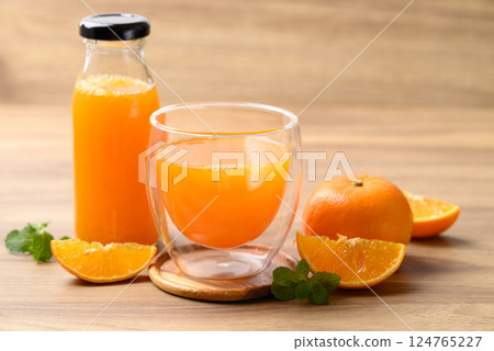 Orange juice in glass and bottle with fresh orange fruit on wooden background, Healthy drink 124765227