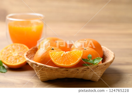 Fresh orange fruit in basket with orange juice on wooden background, Healthy drink 124765228