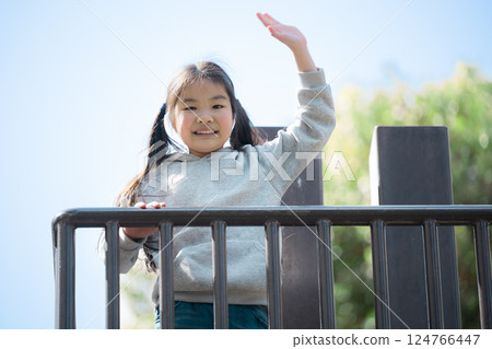 Girl waving hand in the park 124766447