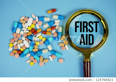 First Aid and Magnifying glass with Difference of Medicine on blue background First Aid and Magnifying glass with Difference of Medicine on blue background 124766921