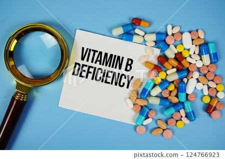 Vitamin B Deficiency text on sticky note paper with Medicine and Magnifying glass on blue background Vitamin B Deficiency text on sticky note paper with Medicine and Magnifying glass on blue background 124766923