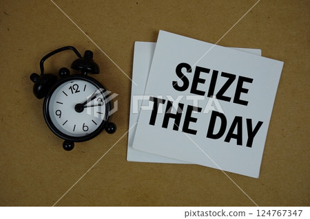Seize The Day text on sticky note with alarm clock on paper craft background 124767347