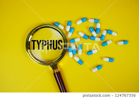 Medicine Capsule and Magnifying glass with Typhus text on green background 124767356