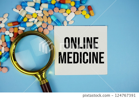 Online Medicine text on sticky note paper with Medicine and Magnifying glass on blue background Online Medicine text on sticky note paper with Medicine and Magnifying glass on blue background 124767391