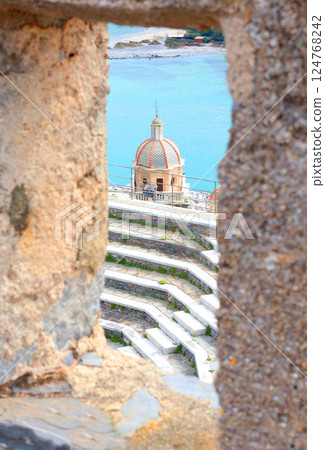 View of old church and amphitheater from stone window in Porto Venere, Italy. Panorama and nature. Sunny day and historical building. View of old church and amphitheater from stone window in Porto Venere, Italy. Panorama and nature. Sunny day and historical building. 124768242