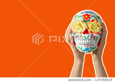 Cinco De Mayo, hands holding skull on orange background Cinco De Mayo, hands holding skull on orange background 124768614